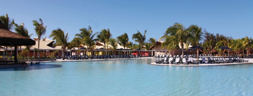 Resort all inclusive en Porto de Galinhas con piscina y palmeras Piscina de resort all inclusive en Porto de Galinhas, Brasil, rodeada de palmeras y camastros.
