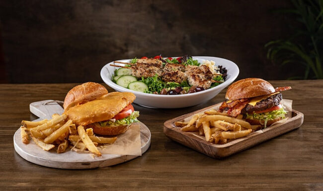 Opciones gastronómicas en SeaWorld Orlando con hamburguesas, papas fritas y platos frescos para toda la familia