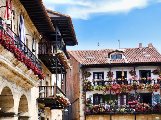 Balcones con flores en Santillana del Mar, joya medieval de Cantabria | Paraviajarporelmundo.com Balcón con flores en Santillana del Mar, Cantabria, ejemplo de la arquitectura tradicional española.