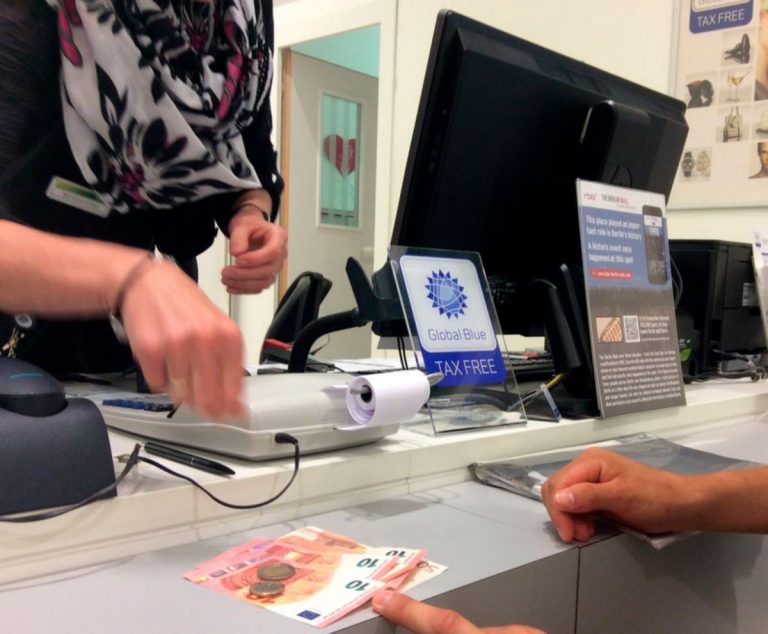 Turista presentando pasaporte y recibos de compras para reembolso de impuestos