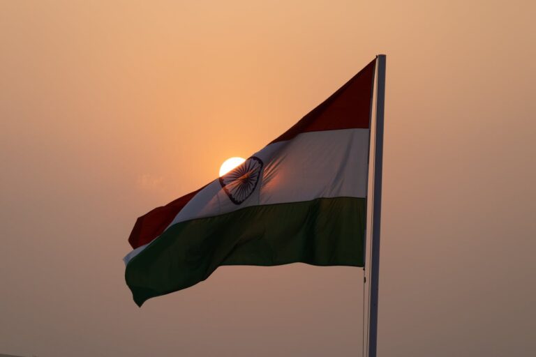 Bandera de India ondeando al atardecer con el sol de fondo