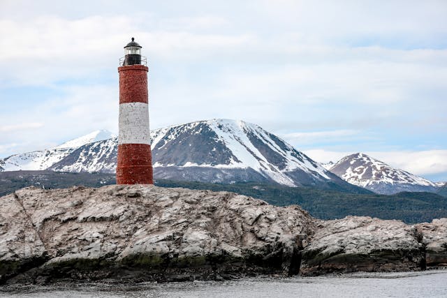 Faro Les Éclaireurs en Ushuaia, Argentina, con montañas nevadas al fondo, uno de los paisajes más emblemáticos del fin del mundo.