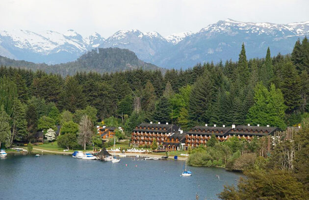 Bahía Manzano en Villa La Angostura Vista de Bahía Manzano en Villa La Angostura, con hoteles, embarcaciones y montañas nevadas de fondo en la Patagonia argentina