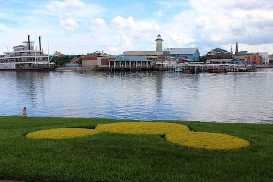 Disney Springs en Orlando con el lago, un barco y flores en forma de Mickey Mouse