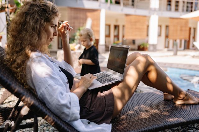 Mujer trabajando con una computadora durante una estadía en el exterior, imagen relacionada con una guía sobre qué es una Working Holiday Visa.