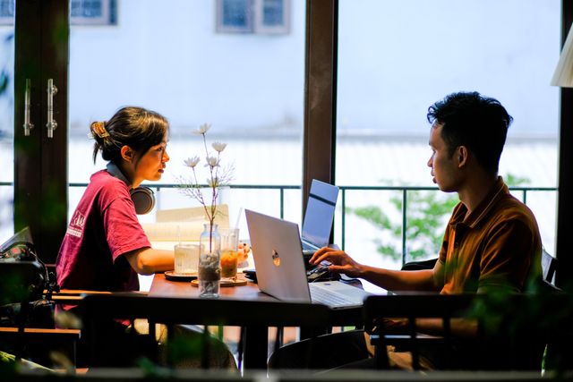Jóvenes trabajando con computadoras durante un viaje, imagen relacionada con una guía sobre qué es una Working Holiday Visa.