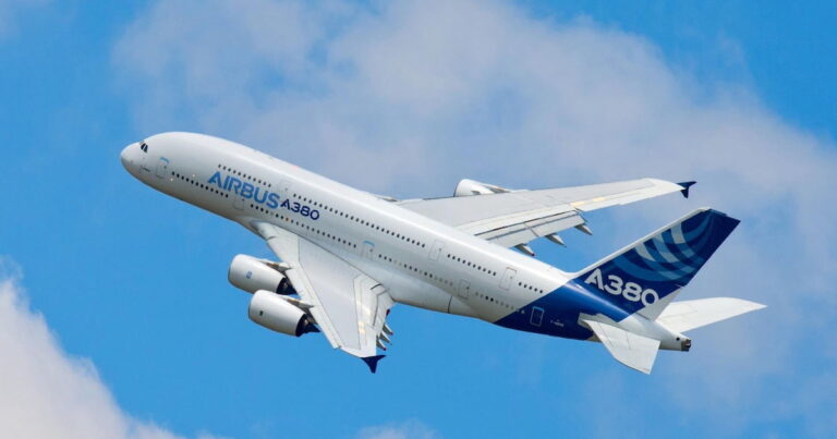 Avión Airbus A380 despegando contra un cielo azul con nubes.