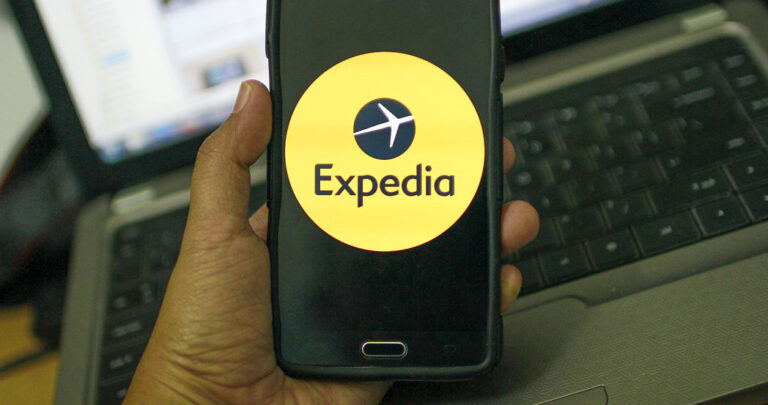 Hombre buscando hotel en Expedia en su movil