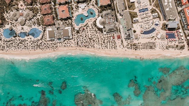 Qué hacer en Punta Cana: vista aérea de hoteles y playas caribeñas Vista aérea de resorts y playa en Punta Cana con mar turquesa