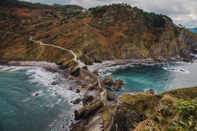 San Juan de Gaztelugatxe: cómo llegar y qué ver en el icónico islote del País Vasco Vista aérea del camino hacia San Juan de Gaztelugatxe, el famoso islote del País Vasco sobre el mar Cantábrico.