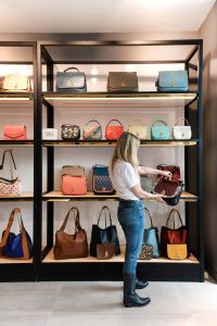 Mujer viendo las ofertas de bolsos y carteras en un comercio 