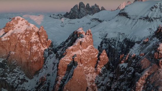 Picos nevados de las Dolomitas en Italia iluminados por la luz del atardecer.