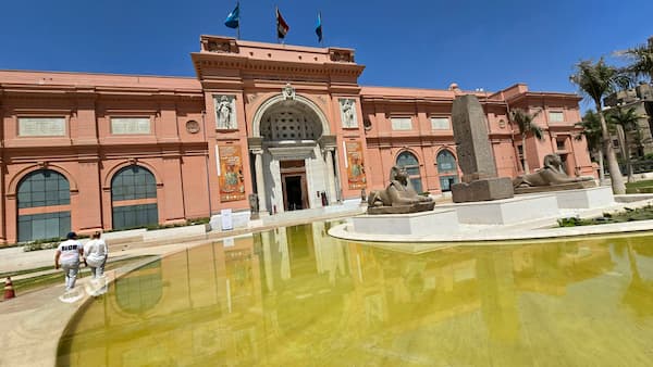 museo egipcio del el cairo. parede color ladrillo y hay una fuente de agua adelante