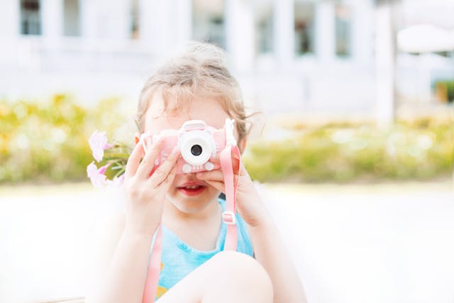 Niña tomando fotos con una cámara de juguete durante unas vacaciones familiares en Punta Cana.
