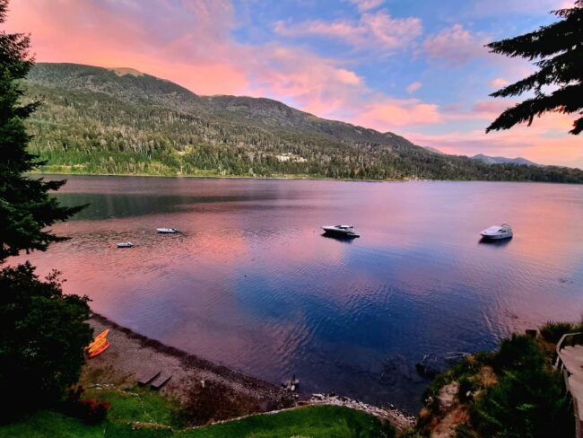 Atardecer sobre el lago Nahuel Huapi con reflejos rosados en Villa La Angostura