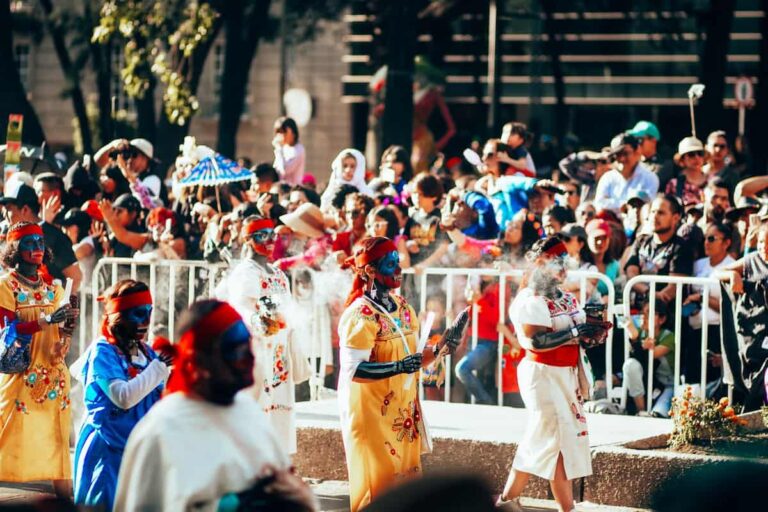 Desfile del Día de los Muertos en México con mujeres maquilladas y vestidas con trajes tradicionales