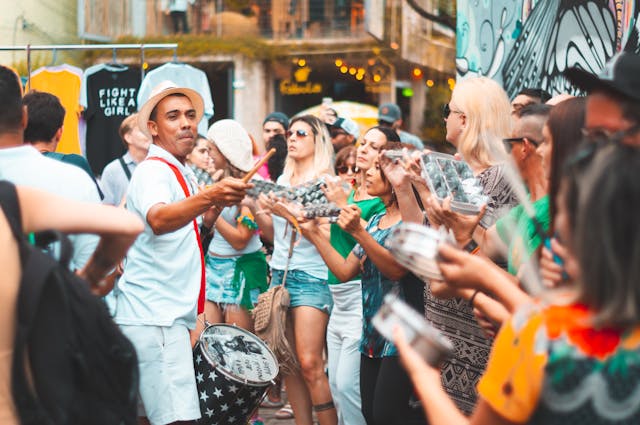 Personas tocando instrumentos de percusión en un festival callejero de Brasil