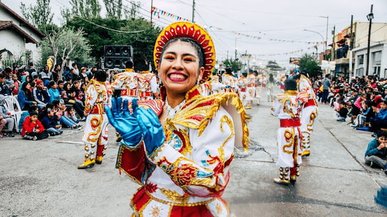 Joven con traje típico bailando en desfile folclórico latinoamericano en la calle