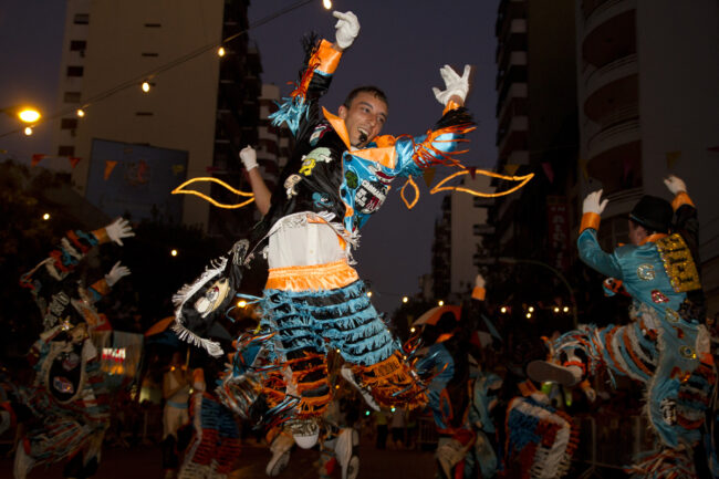 Murga en el carnaval porteño. Murga con bailarín saltando en desfile de carnaval nocturno
