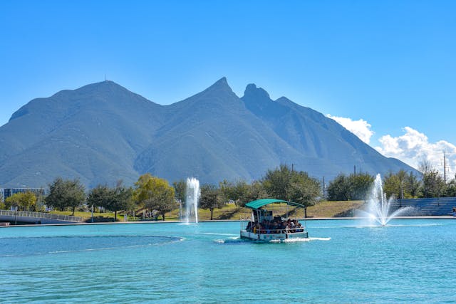Paseo en bote por el canal de Santa Lucía con las montañas de Monterrey al fondo, uno de los planes más recomendados para conocer la ciudad y disfrutar sus paisajes urbanos.
