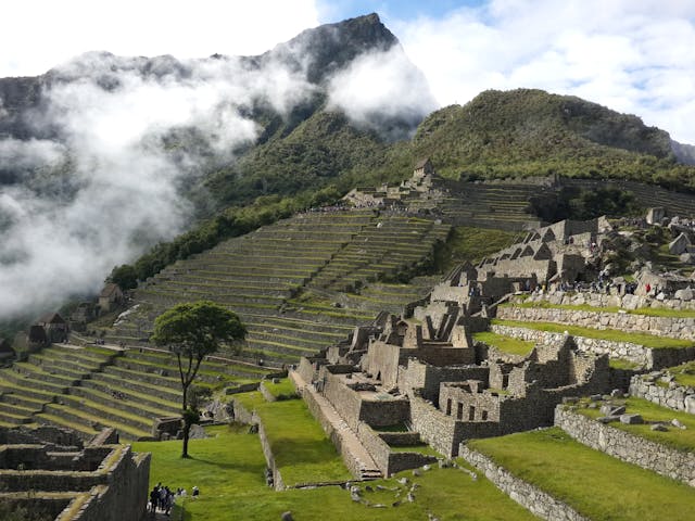 Visitar Machu Picchu en 2026: recorrido, tiempos y qué esperar durante la visita Terrazas de Machu Picchu con visitantes recorriendo el sitio, parte de la experiencia de viaje en Perú