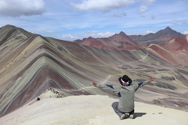 Disfruta la vista desde la Montaña de 7 Colores, el tesoro natural del Cusco peruano Turista disfrutando la vista de la Montaña de 7 Colores en Perú, uno de los paisajes naturales más impresionantes del mundo.