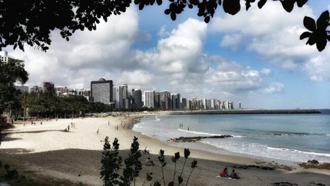 Vista panorámica de la playa de Fortaleza con edificios modernos al fondo.