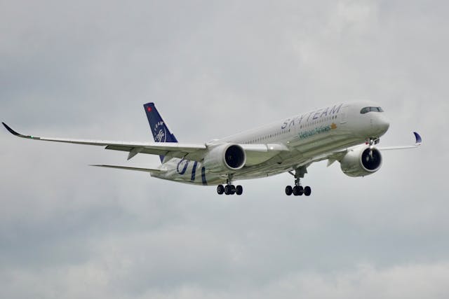 Avión de Vietnam Airlines con librea SkyTeam volando con el tren de aterrizaje desplegado.