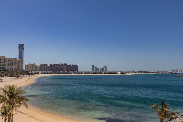 Playa en Dubái con edificios modernos y aguas turquesas del Golfo Pérsico