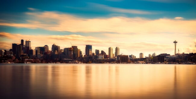 Vista panorámica de la ciudad de Seattle con el Space Needle al fondo, reflejada sobre el agua al atardecer.