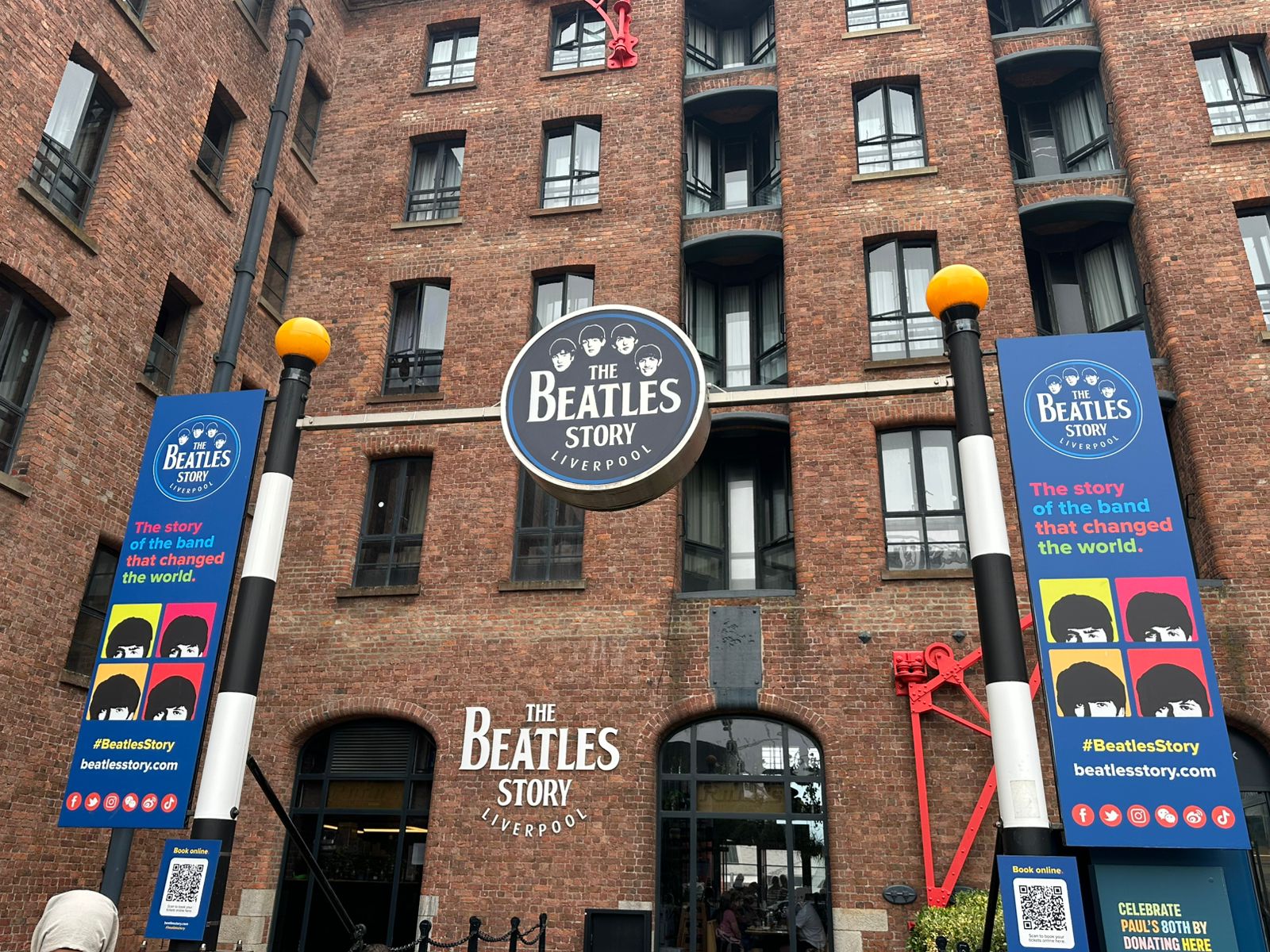 Entrada principal de The Beatles Story en Liverpool, con carteles promocionales del museo.