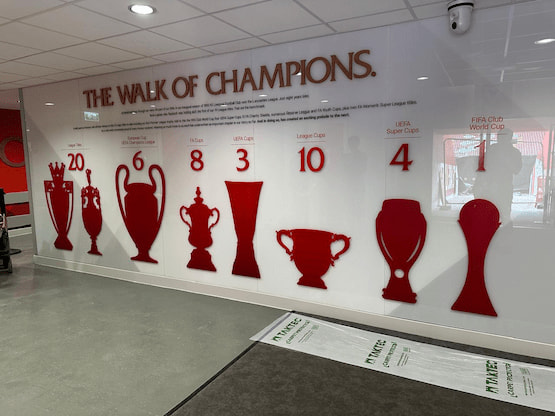 Los trofeos del Liverpool Football Club en su “Paseo de los Campeones”. Pared con siluetas rojas de los trofeos ganados por el Liverpool FC en su historia.