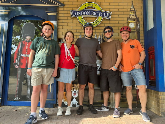 Foto familiar antes del tour en bicicleta por Londres. Familia con cascos de ciclismo posando frente a la fachada de The London Bicycle Tour Company.
