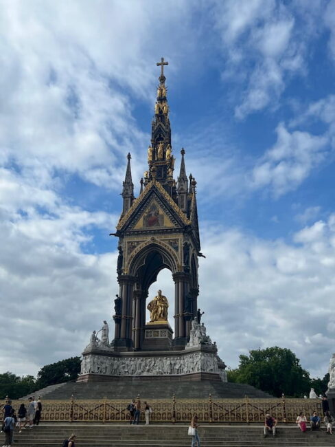 Albert Memorial en Londres, monumento al príncipe consorte. Monumento al Príncipe Alberto en Londres, con cielo parcialmente nublado y visitantes alrededor.