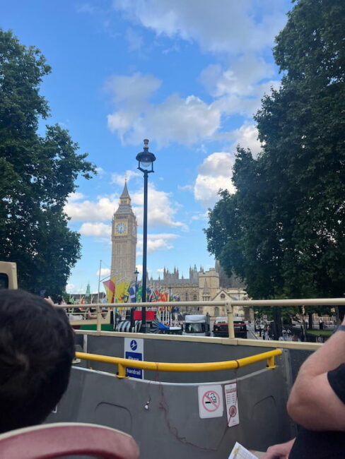 Panorámica del Big Ben desde un bus turístico en Londres. Vista del Big Ben desde la parte superior de un autobús turístico en Londres, con banderas internacionales al frente.