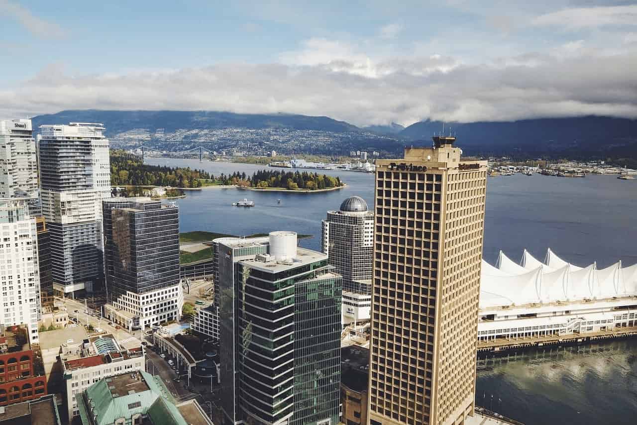 Vista aérea del centro de Vancouver con Canada Place, rascacielos y el puerto con montañas de fondo