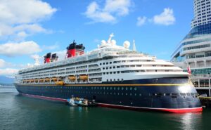 Crucero de Disney atracado en el puerto con sus características chimeneas rojas y negras.