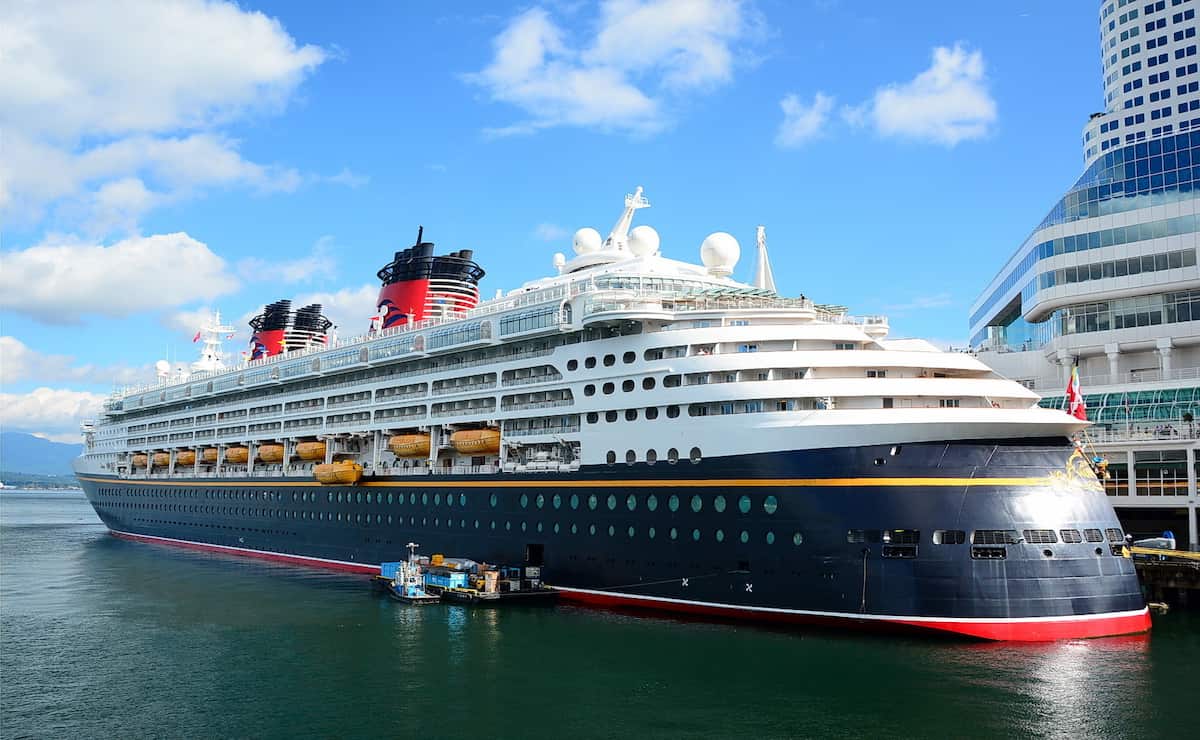 Crucero de Disney atracado en el puerto con sus características chimeneas rojas y negras.
