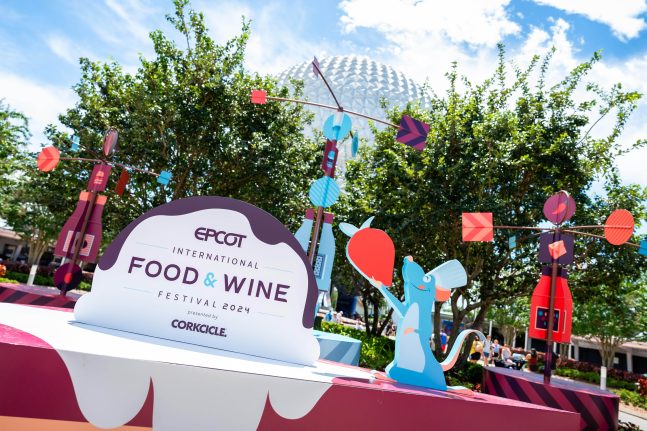 Festival Internacional de Comida y Vino 2024 en EPCOT, Walt Disney World. Cartel del EPCOT International Food & Wine Festival 2024 en Disney World, decorado con personajes animados y con la icónica esfera de fondo.