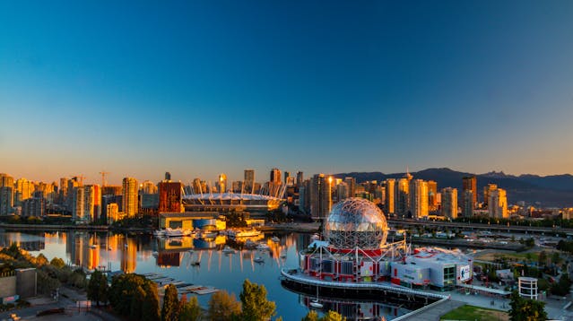 Panorámica de Vancouver al atardecer con el Science World y el estadio BC Place reflejados en el agua