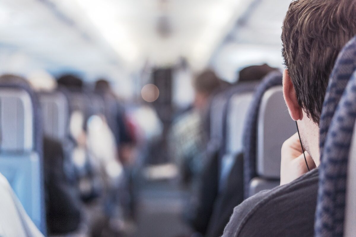Pasajeros dentro de la cabina de avión comercial.