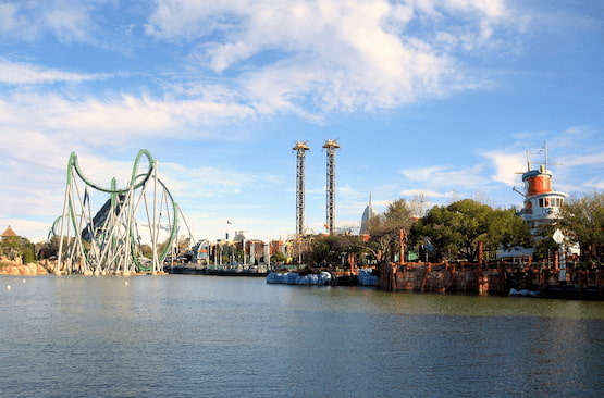 Parque Islands of Adventure en Universal Orlando. Vista panorámica del parque Islands of Adventure en Universal Orlando con montañas rusas y atracciones junto al lago.