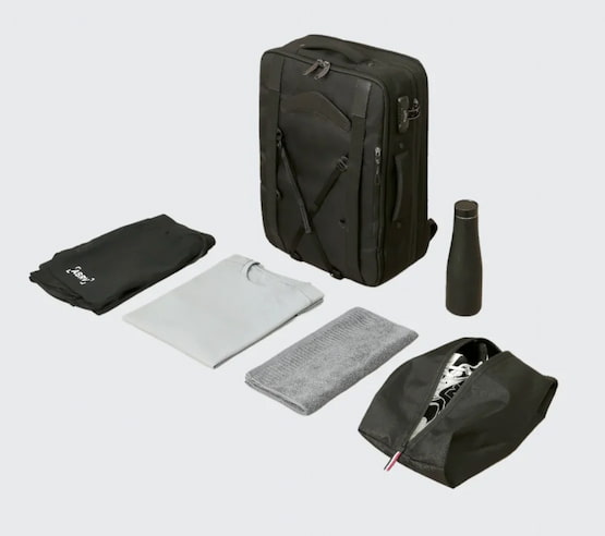 Cómo organizar tu equipaje de forma práctica para viajar ligero. Maleta de viaje con ropa doblada, botella reutilizable y bolsa para calzado organizada.