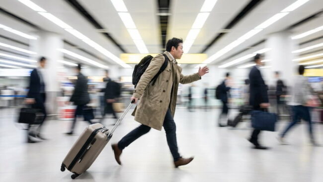 Viajero corriendo por el aeropuerto con valija para no perder una conexión o un vuelo.