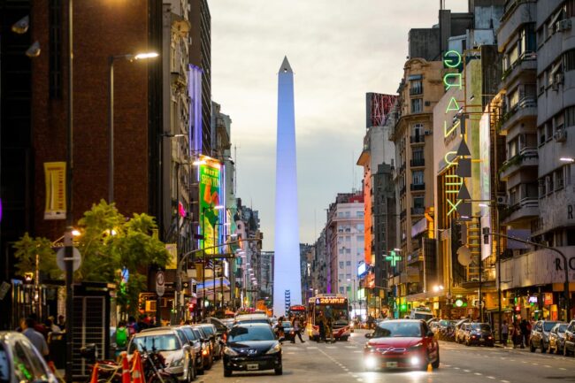 El Obelisco, ícono indiscutido de Buenos Aires Vista aérea nocturna del Obelisco de Buenos Aires iluminado, con tránsito en la Avenida 9 de Julio.