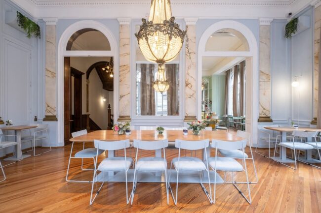 Salón de Amayta con lámpara de araña, espejos y mesa larga en Recoleta.