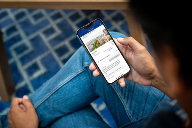 Viajeros comparando alojamientos en Booking.com desde una laptop.