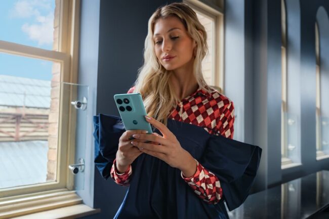 Mujer joven con un teléfono Motorola Edge en su mano, en un hotel en Islandia