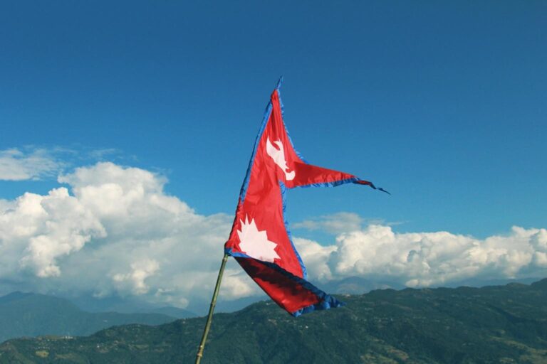 Bandera de Nepal ondeando con el Himalaya de fondo