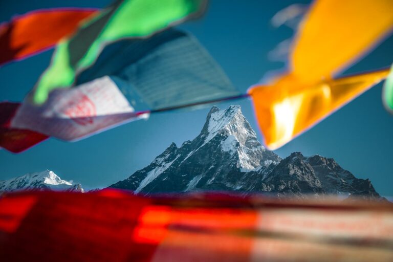 Montaña nevada del Himalaya con banderas de oración tibetanas al frente
